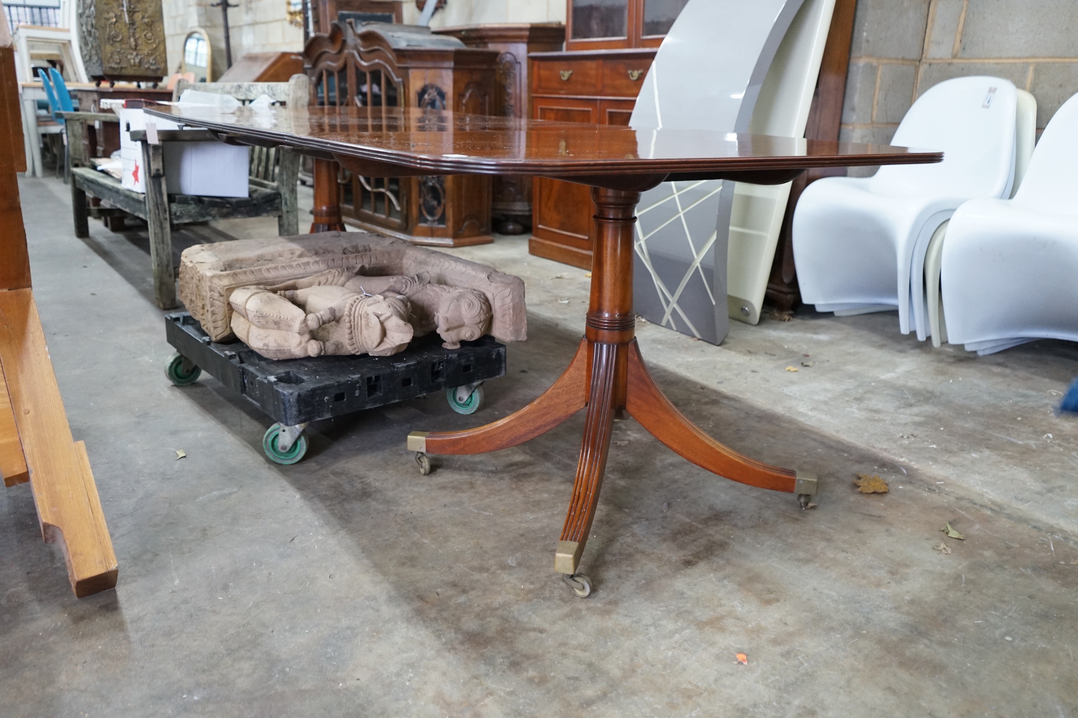 A reproduction Tillman style mahogany twin pillar extending dining table 246cms extended, two spare leaves, width 107cms, height 72cms.